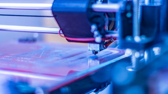 Close-up of a 3D bioprinter nozzle in action, depositing layers for biomedical printing applications.