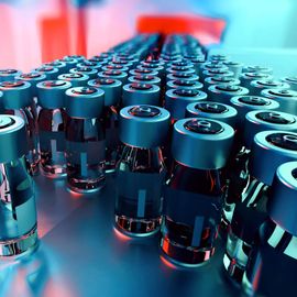 Rows of pharmaceutical vials on a production line, relevant to host cell protein analysis in biologics. 
