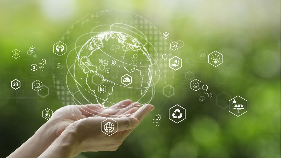 Hands holding a digital Earth with eco icons, symbolizing lab sustainability and green practices.