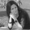 Black and white portrait of a female researcher seated outdoors, looking thoughtfully to the side.