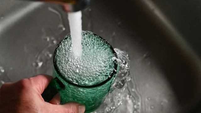 A glass being filled with tap water.